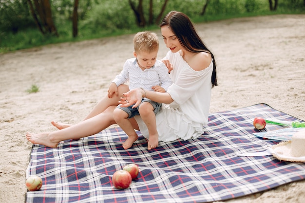 Mère avec fils jouant dans un parc d'été