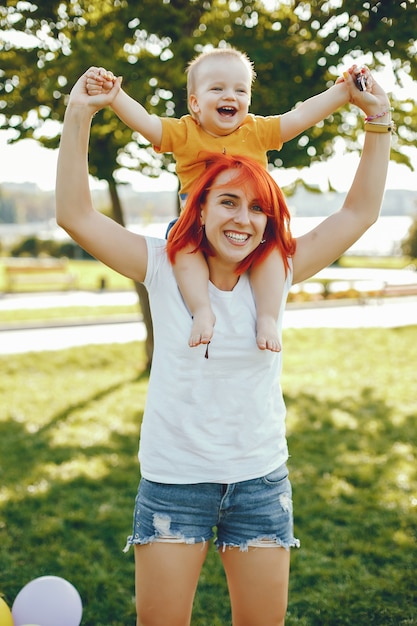 Mère avec fils jouant dans un parc d'été