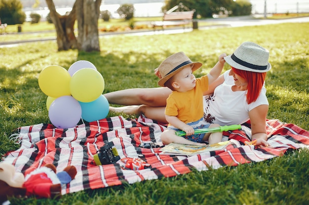 Mère avec fils jouant dans un parc d'été