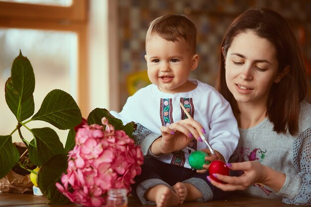 La mère et le fils peignant des oeufs de Pâques