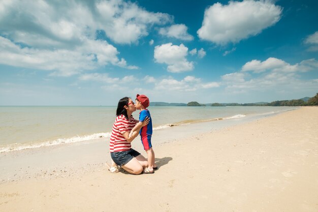 Une mère et un fils sur la plage à l&#39;extérieur Mer et ciel bleu