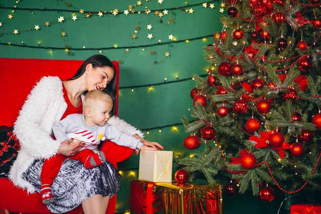 Mère avec fils près du sapin de Noël