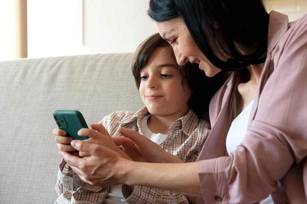 Mère et fils regardant ensemble sur un smartphone