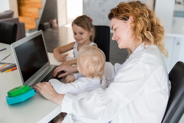 Mère grand angle travaillant avec bébé