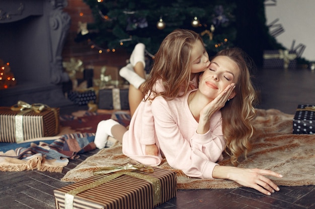 Mère avec jolie fille à la maison près de cheminée