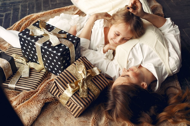 Mère avec jolie fille à la maison près de cheminée