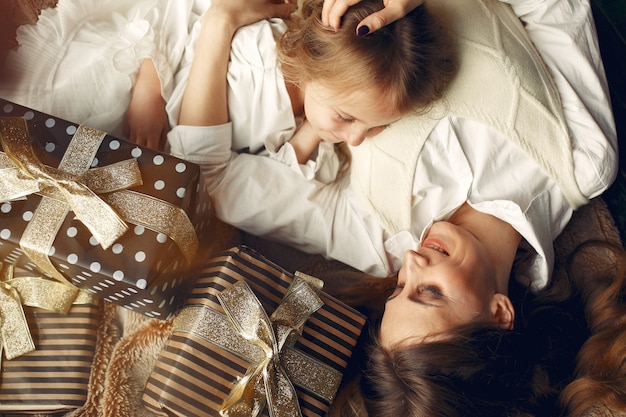 Mère avec jolie fille à la maison près de cheminée