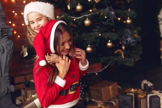 Mère avec jolie fille à la maison près de cheminée