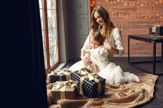 Mère avec jolie fille à la maison près de la fenêtre