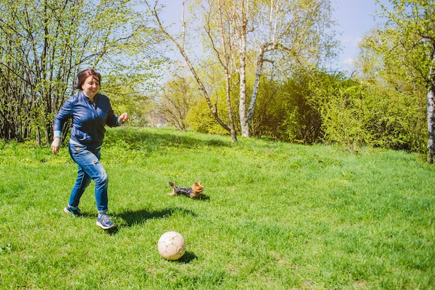 Mère jouant au football dans le parc