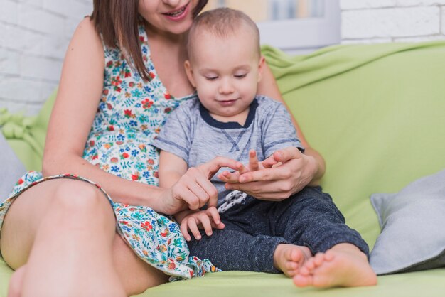 Mère jouant avec les doigts de son fils