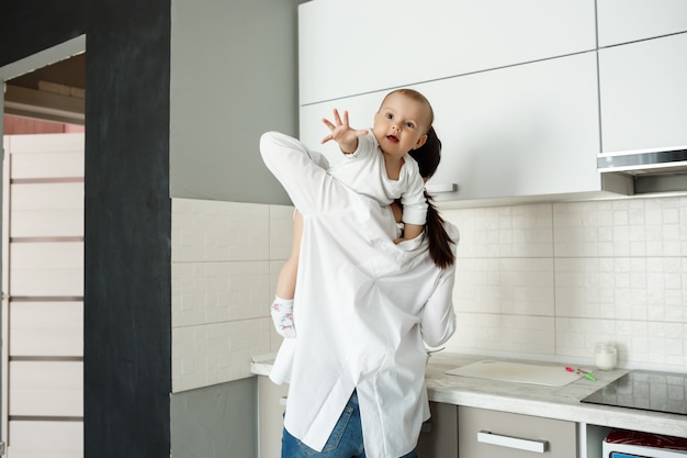 Mère jouant avec petit bébé dans la cuisine