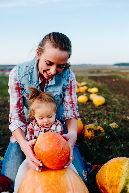 Mère jouant avec sa fille avec des citrouilles