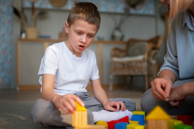 Photo gratuite mère jouant avec son fils autiste à l'aide de jouets