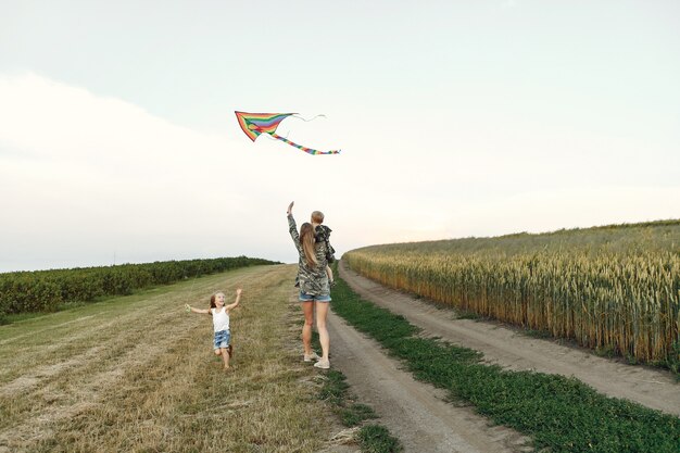 Mère avec mignons petits enfants dans un champ d'été