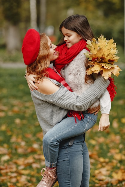 Mère à la mode avec sa fille. Automne jaune. Femme dans un foulard rouge.