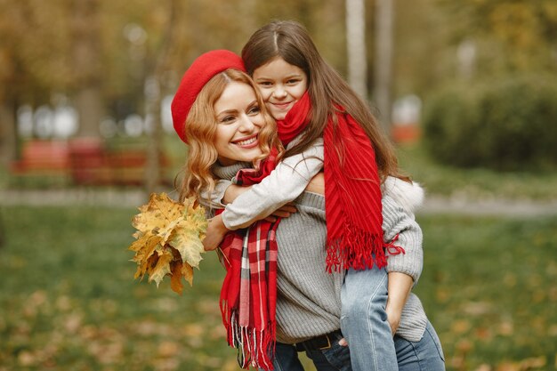 Mère à la mode avec sa fille. Automne jaune. Femme dans un foulard rouge.