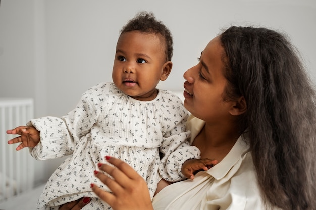 Photo gratuite mère noire prenant soin de son enfant