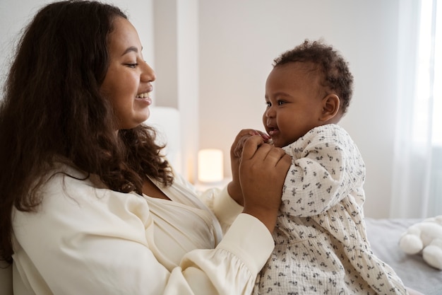 Photo gratuite mère noire prenant soin de son enfant