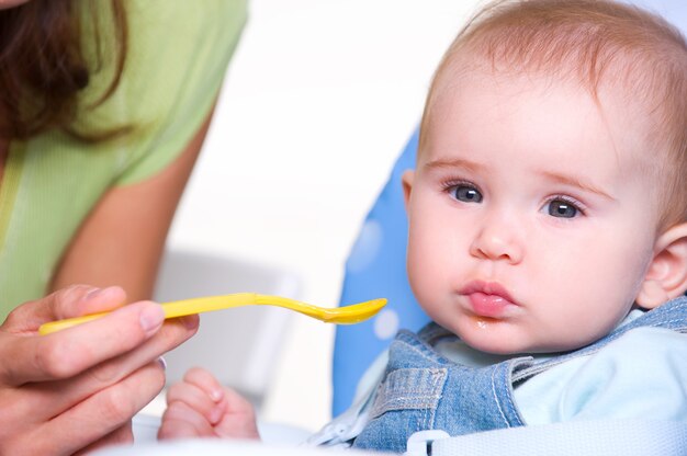 Mère nourrir bébé affamé