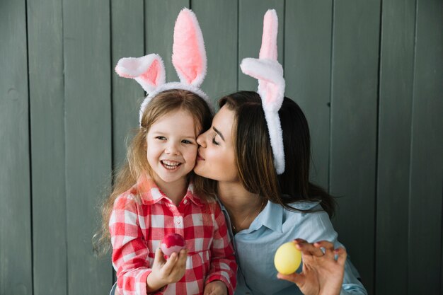 Mère oreilles de lapin embrassant sa fille sur la joue