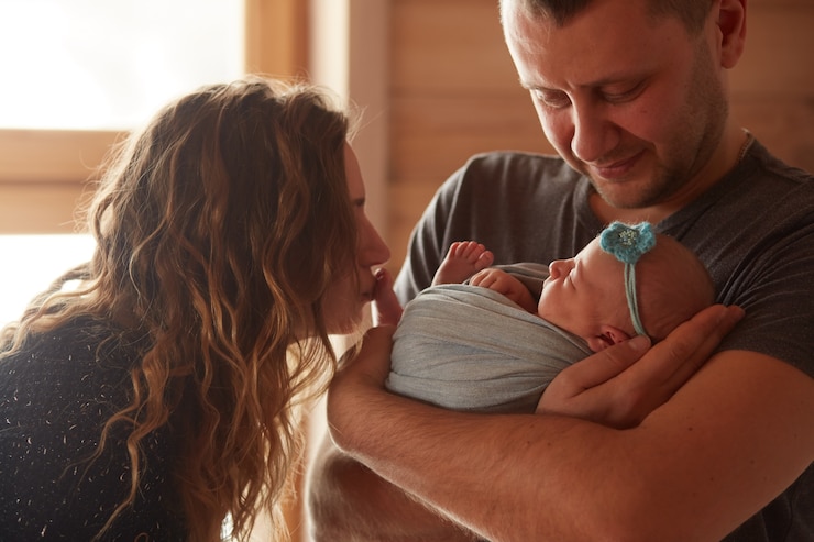 Photo gratuit la mère et le père embrassant leur fille