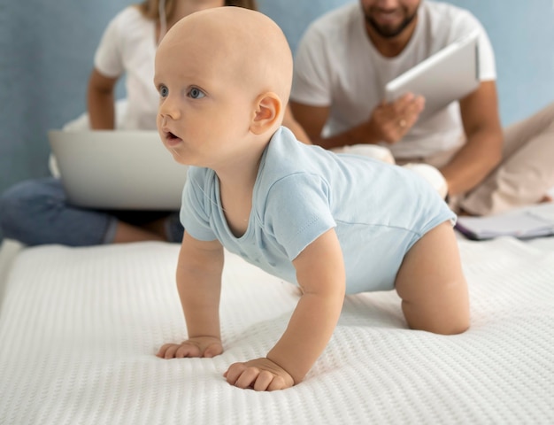 Mère et père travaillant sur un ordinateur portable à la maison pendant la quarantaine avec enfant