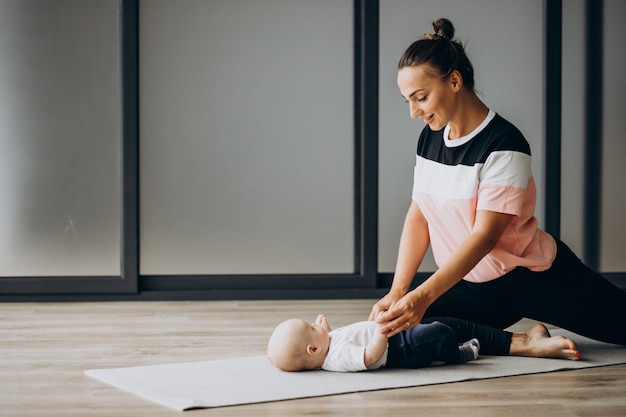 Mère avec petit bébé garçon pratique le yoga