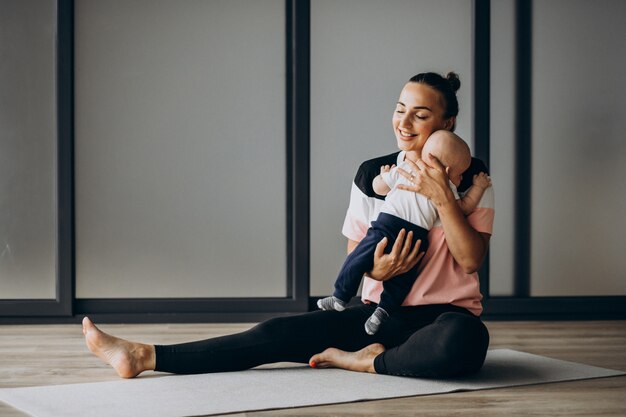 Mère avec petit bébé garçon pratique le yoga