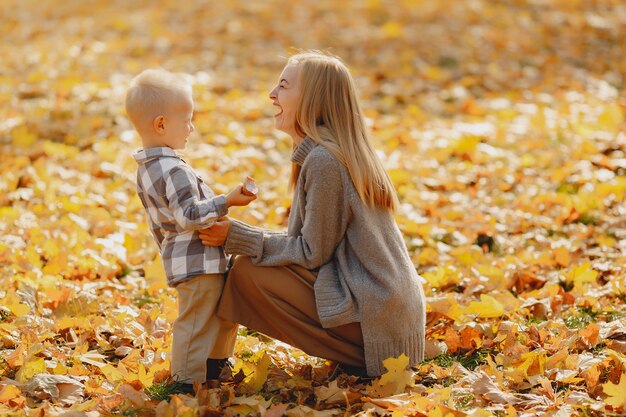 Mère avec petit fils assis dans un champ d'automne