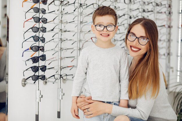 Mère avec petit fils dans le magasin de lunettes