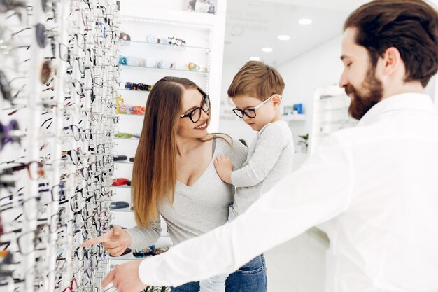 Mère avec petit fils dans le magasin de lunettes