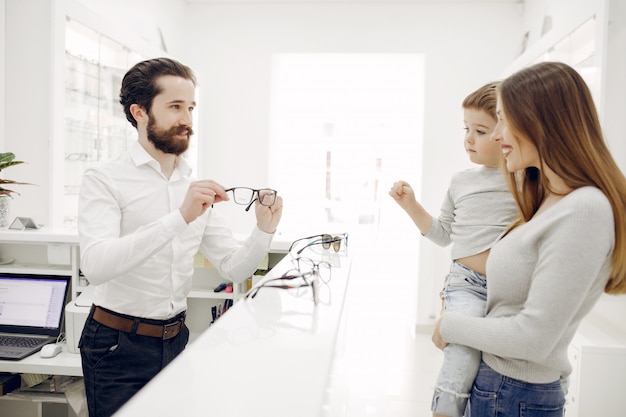 Mère avec petit fils dans le magasin de lunettes