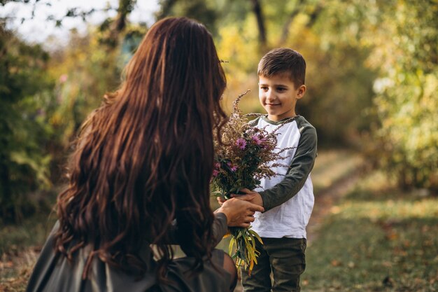 Mère avec petit fils dans un parc en automne