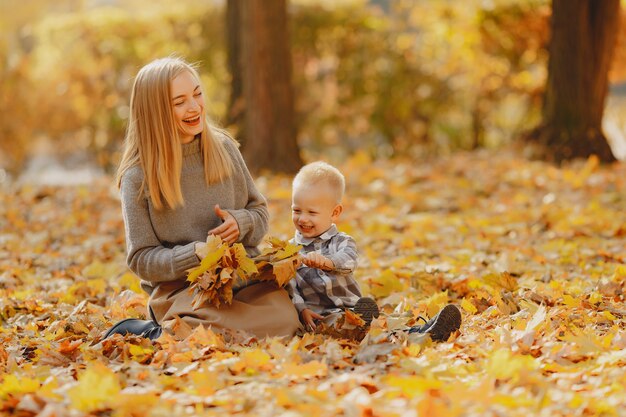 Mère avec petit fils jouant dans un champ d'automne