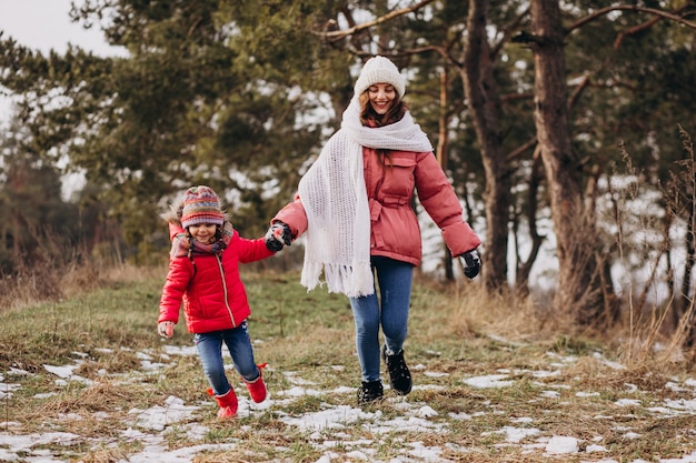 Mère avec petite fille dans une forêt d'hiver