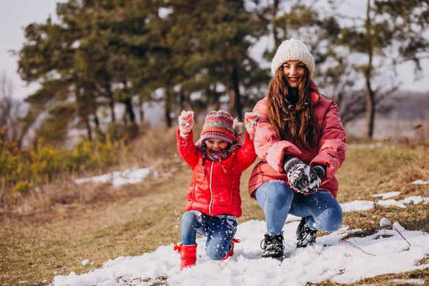 Mère avec petite fille dans une forêt d'hiver