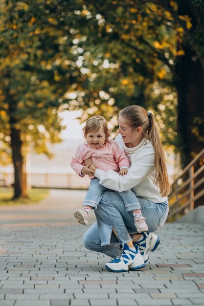 Mère avec petite fille dans le parc automnal