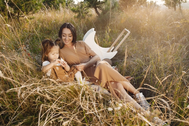 Mère avec petite fille jouant dans un champ d'été