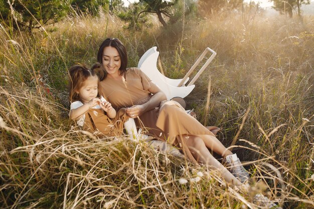 Mère avec petite fille jouant dans un champ d'été