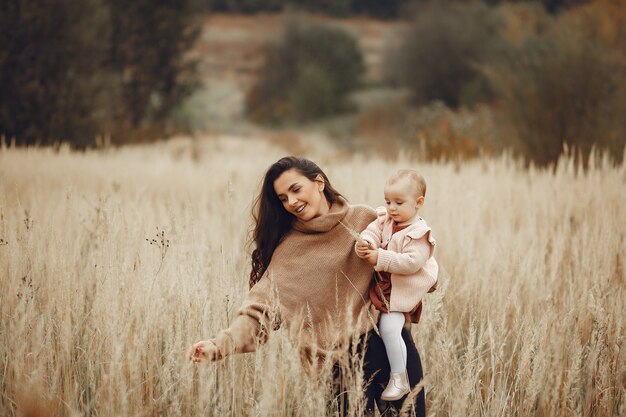 Mère avec petite fille jouant dans un champ