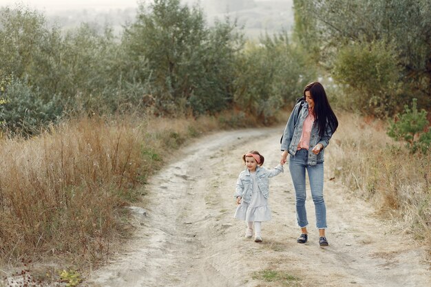 Mère avec petite fille jouant dans un champ