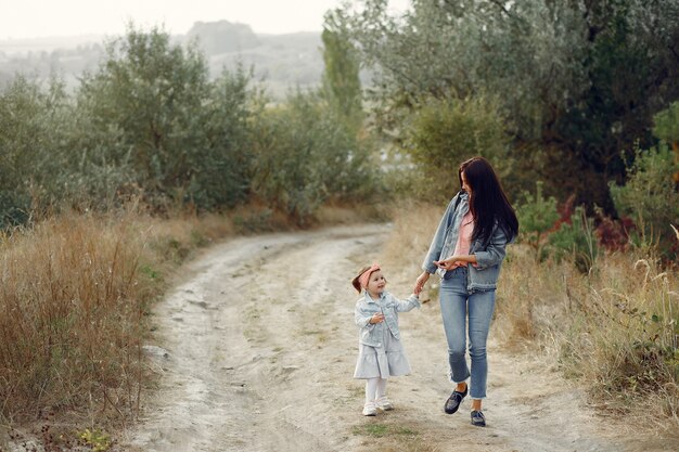 Mère avec petite fille jouant dans un champ