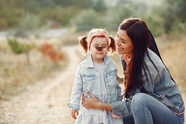 Mère avec petite fille jouant dans un champ