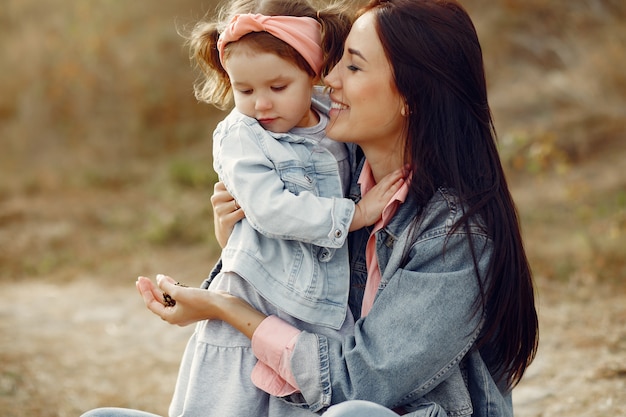 Mère avec petite fille jouant dans un champ