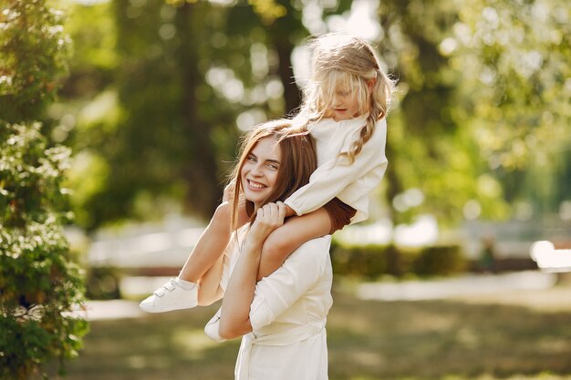 Mère avec petite fille jouant dans un parc d'été