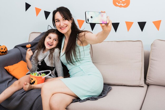 Mère prenant un selfie avec sa fille à l'halloween