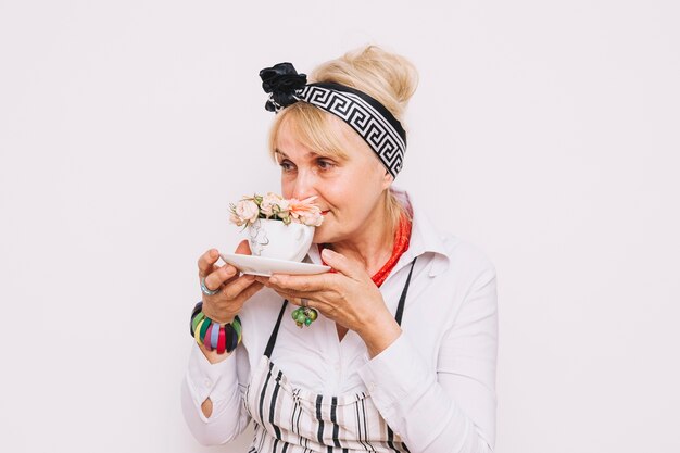 Mère qui sent les fleurs dans la tasse