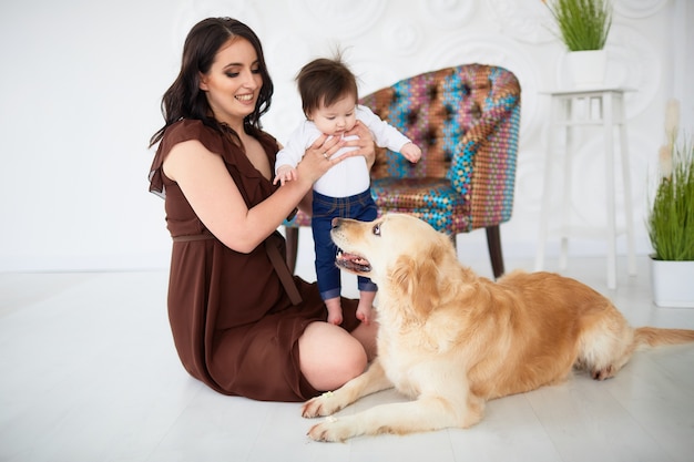 La mère avec sa fille assise sur le sol et regardant le chien