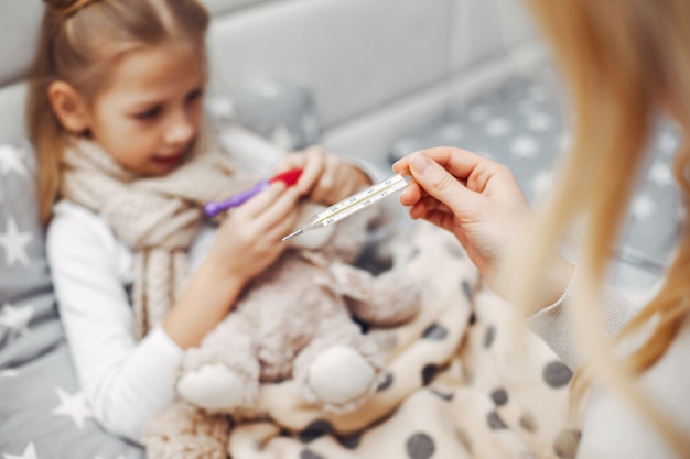 Photo gratuite mère avec sa fille illnes dans une chambre à coucher